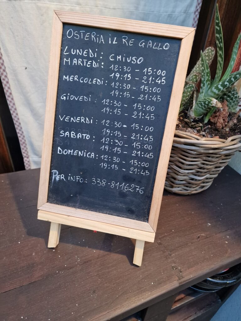 Kruitbord met openingstijden van Il Re Gallo in Castellina in Chianti